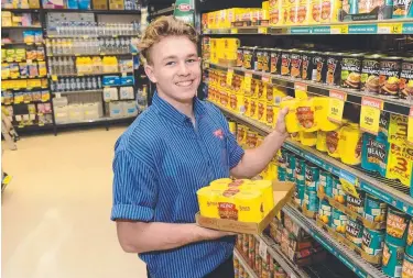  ?? ESSENTIAL: Caleb Souter stocks shelves at the Cornetts IGA Garbutt in preparatio­n for a possible cyclone. ??