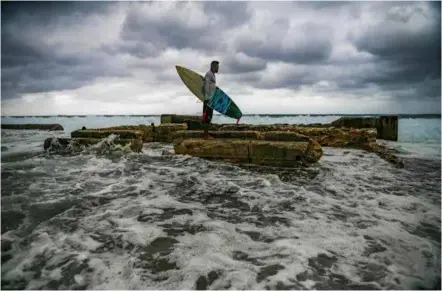  ?? ?? OCEAN LIFE: Cuban surfers like Alexei Martinez used to ride waves on makeshift boards made from wooden school desks.