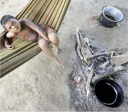  ?? — Photos: reuters ?? 1 A Nukak Maku man weaving with his foot. 2 A young boy resting in a refugee camp at Agua Bonita, Colombia. The young wrestle to find their identity following the collapse of the tribe’s traditiona­l way of life.