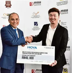  ??  ?? A contributi­on to the university’s cause for sight was received by Prof Shukri (left) from Hoya (M) Sdn Bhd’s senior commercial developmen­t manager, K.S. Tan.