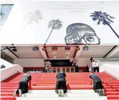  ?? — AFP ?? Staff roll the red carpet as the 74th edition of the Cannes Film Festival kicks off in Cannes on Tuesday.