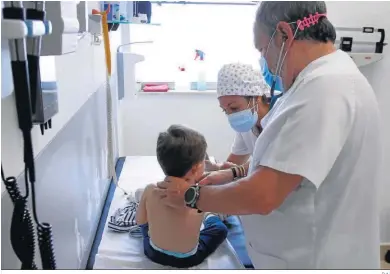  ?? D.A. ?? Pediatras realizan un reconocimi­ento médico a un niño.