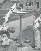  ?? HARRIS W. NOWELL/MILWAUKEE JOURNAL ?? A boy gives a dog a boost at a bubbler, as his friend looks on. This photo was published in the Aug. 28, 1938, Milwaukee Journal’s photo section.