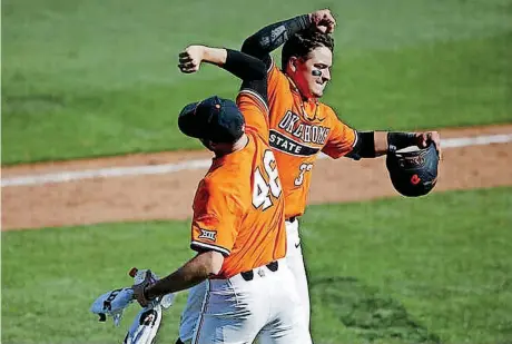  ?? [PHOTO BY IAN MAULE, TULSA WORLD] ?? Oklahoma State outfielder Trevor Boone, right, celebrates with pitcher Joe Lienhard after hitting a solo home run on Sunday during the Bedlam baseball game against Oklahoma at ONEOK Field in Tulsa. OSU beat the Sooners, 9-2.