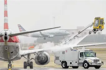  ?? Lola Gomez/Associated Press ?? An American Airlines plane at Dallas-Fort Worth Internatio­nal Airport gets deiced Monday. The president asked Congress to limit the extra fees some airlines charge for assigned seating.