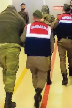  ??  ?? Türkische Polizisten führen die griechisch­en Soldaten Angelos Mitretodis und Dimitris Kouklatzis in Edirne ab.