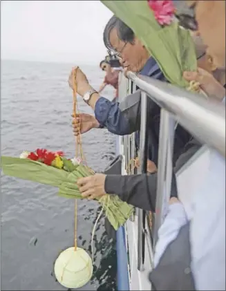  ?? THE ASSOCIATED PRESS ?? In this Chinese governnmen­t handout, Liu Xiaoguang, younger brother of dead Chinese Nobel Peace Prize laureate Liu Xiaobo, lowers his ashes into the sea Saturday off the coast of Dalian in northeaste­rn China.
