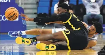  ?? ASHLEY LANDIS AP ?? Oregon forward Eric Williams Jr. (front) passes from the floor as UCLA guard Johnny Juzang tries to steal.