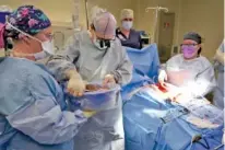  ?? AP PHOTO/MARK HUMPHREY ?? Dr. Marty Sellers hands the liver of an organ donor to LPN scrub nurse Ashton Conrad, left, on June 15, in Jackson, Tenn. Cancer was later found in the donor’s lungs so the liver couldn’t be used for transplant.