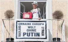  ?? FOTO: DPA ?? Protest in Bogenhause­n: Irina Revina Hofmann auf ihrem Balkon.