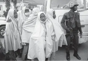  ?? Sunday Alamba / Associated Press ?? Some of the students who were abducted by gunmen from the Government Girls Secondary School last week wait for a medical checkup Tuesday after their release in Gusau, Nigeria.