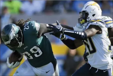  ?? MARK J. TERRILL — THE ASSOCIATED PRESS ?? Philadelph­ia Eagles running back LeGarrette Blount, left, gets a hand on the face mask of Los Angeles Chargers defensive back Desmond King (20) as he runs during the second half of an NFL football game Sunday in Carson