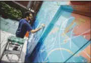  ?? ASSOCIATED PRESS ?? In a photo taken last week and provided by Kiehl’s, artist Jose Parla paints a mural at the Incarnatio­n Children’s Center in New York.