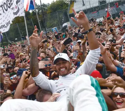  ??  ?? Mesmo na casa da Ferrari, em Monza, Hamilton vence com a Mercedes e comemora nos braços da torcida