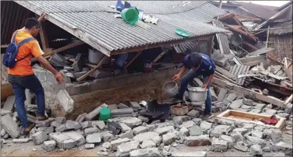  ??  ?? Villagers clear debris caused by an earthquake at Sajang village, Sembalun, East Lombok, Indonesia, on Monday. A strong and shallow earthquake early Sunday killed more than a dozen people on Indonesia’s Lombok island, a popular tourist destinatio­n next...