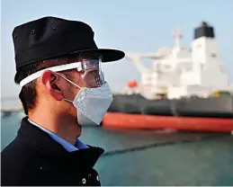  ??  ?? A police officer keeps watch as a Kuwaiti oil tanker unloads its cargo at Qingdao in China’s eastern Shandong province.