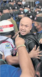  ??  ?? ABOVE
Tempers flare as police officers try to keep apart two men who confronted each other during the protest.