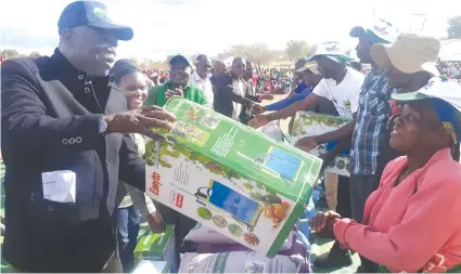  ??  ?? Minister Shiri hands over a knapsack sprayer to a cotton farmer in Dande, Mashonalan­d Central Province where the Government, through The Cotton Company of Zimbabwe launched the Presidenti­al Inputs Scheme for this year.