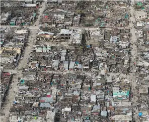  ?? LOGAN ABASSI / AFP / GETTY IMAGES ?? Homes throughout Haiti were reduced to piles of rubble, with roofs either mangled or stripped completely away, leaving tens of thousands homeless. “Jeremie might get rebuilt after I’m dead, maybe, but I doubt it,” said resident Solette Phelicin, a...