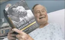  ?? Paul Morse/ Office of George H. W. Bush via AP ?? Former President George H. W. Bush in his hospital bed June 1 while reading a book about himself and his late wife in Biddeford, Maine.