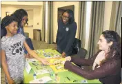  ??  ?? Stefania Bianco, community educator parent coach of the Southern Maryland ABC (Attachment Biobehavio­ral Catch-Up) Program, and Nicole Wright, Charles County Department of Health community health outreach worker, give Zionna Proctor, 10, stickers and a...