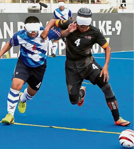  ??  ?? It’s mine: Malaysia’s Muhamad Azuan Abdul Rasiad (right) tussling for the ball with Thailand’s Chinakorn Pongsapang in their five-a-side football (visually impaired) match at the National Hockey Stadium in Bukit Jalil yesterday.