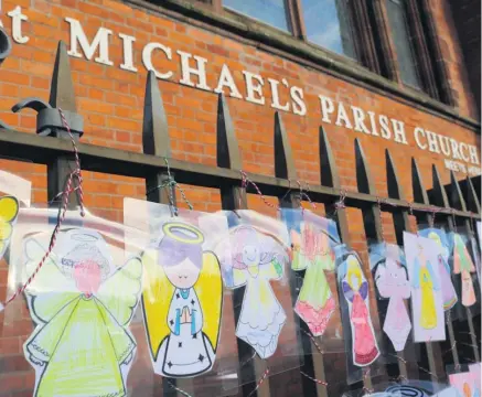  ??  ?? Community effort: the railings of St Michael’s Church, off Belfast’s Shankill Road, have been transforme­d by the appearance of a host of angels