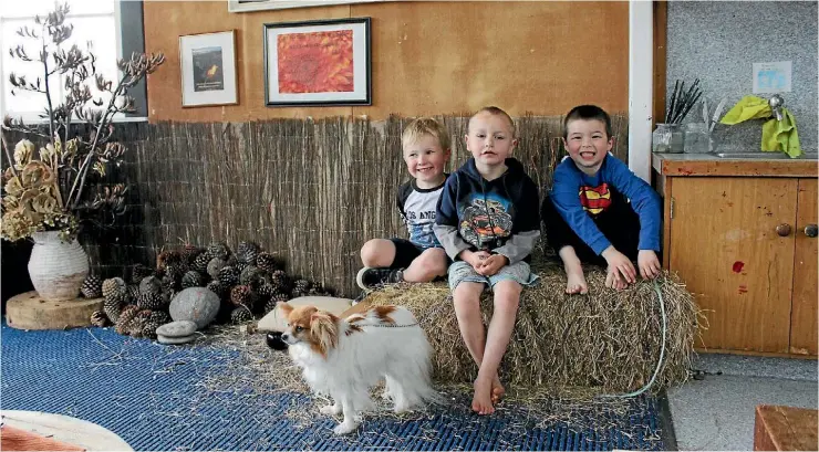  ?? JANE MATTHEWS/STUFF ?? Thomas Callingham, Karlos Robinson and Leighton Harris and Paprika the dog are full of smiles in Room 13 at Stratford Primary School.