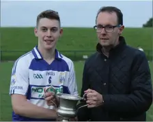  ??  ?? Kieran Linehan, presents the Division 2 Football Championsh­ip cup, to Fionn Magner, Captain of Killavulle­n Minor team 2019.