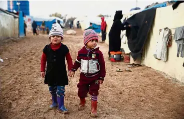  ?? — AFP ?? Children of war: Syrian children walking past tents at a camp for the displaced near the village of Shamarin, near the border with Turkey in the northern Aleppo province.