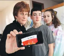  ?? JASON KRYK ?? Nicole Morin, left, and her kids John, 13, and Katie, 14, show a photo of the cup tab that indicates she won $100 after rolling up the rim.