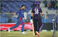  ?? EPA; Getty Images ?? Top, cricket has been a unifying force in Afghanista­n in recent years. Above, Afghanista­n’s Rashid Khan celebrates taking the wicket of Scotland’s Brad Wheal in Sharjah