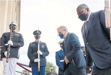  ?? DREW ANGERER GETTY IMAGES ?? Australian Prime Minister Scott Morrison, centre, and U.S. Defence Secretary Lloyd Austin walk past an honour guard before a meeting at the Pentagon Wednesday. It was a good thing Canada was excluded from AUKUS, Rick Salutin writes.