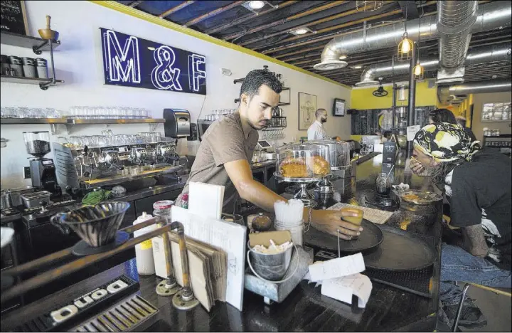  ?? ERIK VERDUZCO/LAS VEGAS REVIEW-JOURNAL FOLLOW @ERIK_VERDUZCO ?? Barista Marco Aguila completes a coffee order at Makers & Finders Coffee downtown. The owners traveled to South America to learn about coffee from the farm to the table.