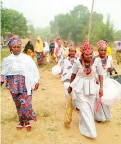  ??  ?? Female members of the age-grade in a procession.