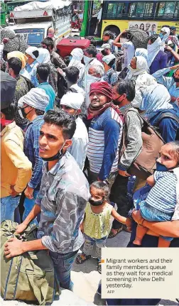  ?? AFP ?? Migrant workers and their family members queue as they wait for a medical screening in New Delhi yesterday.