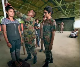  ?? PTI ?? ONE-STEP CLOSER TO JOINING THE ARMY: An army personnel check the height of a shortliste­d candidate during a recruitmen­t drive for women military police as soldier general duty, at the AMC Ground in Lucknow, on Thursday. —