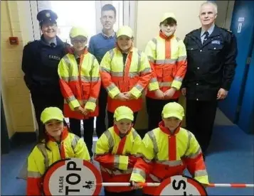  ??  ?? Garda Lisa McEntee with Adrian O’Sullivan, Road Safety Officer, and Sergeant Joseph Hodgins with Tallanstow­n N.S Junior Wardens