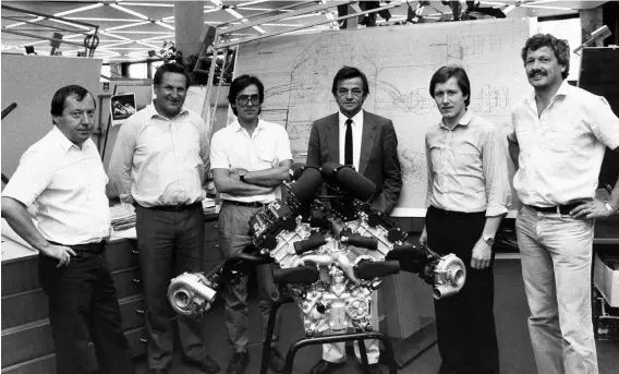  ??  ?? Above: Hans Mezger (in suit) behind the Porsche TAG engine. From left to right are Hans Bischof, Bruno Anklam, Joachim Kelm, Hans Mezger, Dieter Nowack and Peter Schmid. Photo taken in September 1983