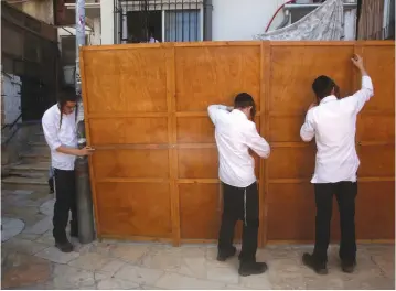  ?? (Reuters) ?? YOUTH BUILD a Succa in Jerusalem.