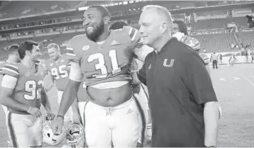  ?? LYNNE SLADKY/AP ?? Miami coach Mark Richt hugs defensive lineman Demetrius Jackson after the Hurricanes’ victory over Pittsburgh.