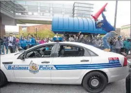  ?? Andrew Caballero-Reynolds
AFP/Getty Images ?? THOUSANDS JOINED the demonstrat­ion, with some protesters targeting police cars and businesses. Freddie Gray’s twin sister spoke out, appealing for calm.