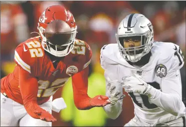  ?? AP/CHARLIE RIEDEL ?? (Above) Kansas City Chiefs safety Juan Thornhill (22) intercepts a pass intended for Oakland Raiders wide receiver Keelan Doss (18) and returns it for a touchdown during the first half Sunday in Kansas City, Mo. (Right) Kansas City tight end Travis Kelce (87) is tackled by Oakland cornerback Daryl Worley (20) during the second half.