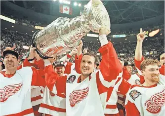  ?? TOMPIDGEON, AP ?? Captain Steve Yzerman, center, raises the Stanley Cup on June 7, 1997, when the Red Wings ended their 42- year title drought.