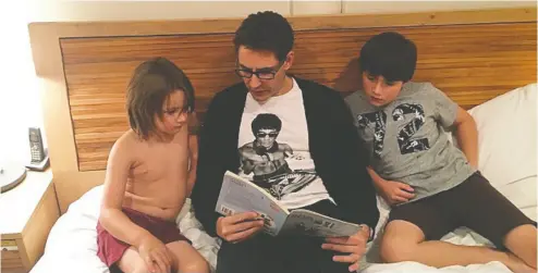  ??  ?? Michael Kovrig, a Bruce Lee fan and doting uncle, reads a Chinese children’s book to his two nephews, Kai and Sebastian, at his sister Ariana’s Toronto home in 2016.
