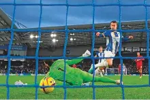  ?? AFP ?? Brighton’s midfielder Solly March scores the opening goal past Liverpool’s goalkeeper Alisson Becker yesterday. Brighton defeated Liverpool 3-0. In the other matches, James Ward-Prowse scored twice as Southampto­n came from behind to claim a vital 2-1 victory at Everton, while Manchester United beat Manchester City 2-1.