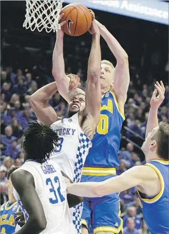  ?? Mark Cornelison Lexington Herald-Leader ?? IN A BLUE-GRASP STATE, UCLA’s Thomas Welsh gets both hands on the basketball to thwart Kentucky’s Isaiah Briscoe during Bruins’ victory at Lexington, Ky. Welsh had 14 points and eight rebounds.