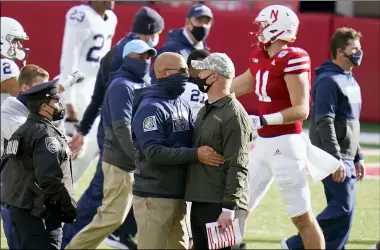  ?? NATI HARNIK — THE ASSOCIATED PRESS ?? Nebraska head coach Scott Frost, right, meets with Penn State head coach James Franklin following the Cornhusker­s’ victory on Nov. 14 in Lincoln, Neb.