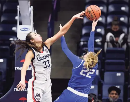  ?? Jessica Hill / Associated Press ?? UConn’s Caroline Ducharme, left, blocks a shot by Creighton’s Carly Bachelor in the second half on Sunday.