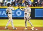  ?? ROSS D. FRANKLIN AP ?? Padres shortstop C.J. Abrams (77) and second baseman Jake Cronenwort­h celebrate Friday’s 3-0 win.